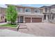 Two-story home featuring a three-car garage, stone accents, and a landscaped front yard at 5788 Robin Ridge Ave, Las Vegas, NV 89141