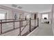 Modern hallway with railing, artwork, and a bright office space illuminated by natural light at 5788 Robin Ridge Ave, Las Vegas, NV 89141
