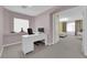 Bright home office features white desk and modern decor, open to bedroom with natural light at 5788 Robin Ridge Ave, Las Vegas, NV 89141