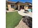 Backyard featuring a covered patio, artificial grass, desert landscaping, and a swimming pool at 6009 Arbor Crest St, North Las Vegas, NV 89081