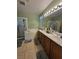 Bright bathroom with tile flooring, double vanity and a tub and shower at 6009 Arbor Crest St, North Las Vegas, NV 89081