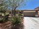 Charming single-story home featuring a stone facade, two-car garage, and mature landscaping at 6009 Arbor Crest St, North Las Vegas, NV 89081