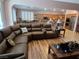 Open-concept living area with a large sectional sofa, hardwood floors, and seamless access to the kitchen at 6009 Arbor Crest St, North Las Vegas, NV 89081