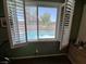 A window view looking onto the pool with white shutters partially open at 6009 Arbor Crest St, North Las Vegas, NV 89081