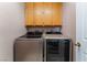 Bright laundry room with upper cabinets above modern washer and dryer at 6224 Mandarin Dr, Las Vegas, NV 89108