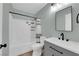 Modern bathroom features a gray vanity, and a shower-tub combination with tiled walls at 638 Ribbon Grass Ave, Las Vegas, NV 89183
