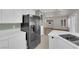 View of the kitchen with stainless steel refrigerator and connecting living space with hardwood floors at 638 Ribbon Grass Ave, Las Vegas, NV 89183