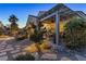 A beautiful backyard features a covered patio area with desert landscaping and a stone path at 6413 White Tiger Ct, Las Vegas, NV 89130