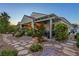Beautiful backyard with a covered patio, stone pathway, desert landscaping, and ambient lighting at 6413 White Tiger Ct, Las Vegas, NV 89130