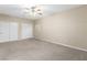 Spacious bedroom featuring a ceiling fan, neutral walls, and carpeted floor, complemented by closet storage at 6413 White Tiger Ct, Las Vegas, NV 89130