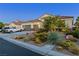 Single-Gathering home with desert landscaping, three-car garage, and well-maintained lawn on a tree-lined street at 6413 White Tiger Ct, Las Vegas, NV 89130