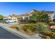 Single-story home featuring a three-car garage, desert landscaping, and a tile roof at 6413 White Tiger Ct, Las Vegas, NV 89130