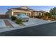 Lovely home boasts a three-car garage, desert landscaping, and plenty of parking space in the driveway at 6413 White Tiger Ct, Las Vegas, NV 89130