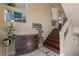 Inviting entryway featuring a dark wood chest, staircase, and neutral walls with decorative cutouts at 6705 Philharmonic Ave, Las Vegas, NV 89139