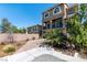 Attractive two-story home with a private balcony, arched windows, and a lush garden area at 6705 Philharmonic Ave, Las Vegas, NV 89139