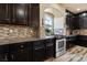 Gourmet kitchen features dark wood cabinetry and custom backsplash at 6705 Philharmonic Ave, Las Vegas, NV 89139