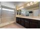 Bright main bathroom with double sinks, a large shower, and a walk-in closet at 6705 Philharmonic Ave, Las Vegas, NV 89139