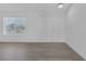 Bright living room with new gray flooring, a window, and a white door at 6808 Waterhen Cir, Las Vegas, NV 89108
