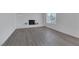 Spacious living room boasting new gray flooring, a white-painted brick fireplace and a window at 6808 Waterhen Cir, Las Vegas, NV 89108