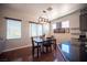 Dining room with hardwood floors, modern light fixture, and open to modern kitchen at 7021 Salt Marsh Ct, Las Vegas, NV 89148