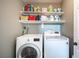 Efficient laundry room featuring a modern washer and dryer with organized shelving above, offering convenience at 7021 Salt Marsh Ct, Las Vegas, NV 89148