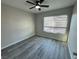 Bedroom featuring grey laminate wood flooring, ceiling fan, and window with blinds at 7144 Forest Vista St, Las Vegas, NV 89147