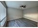 Bedroom with grey laminate wood flooring, window with blinds, and modern ceiling fan at 7144 Forest Vista St, Las Vegas, NV 89147