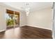 Bright bedroom with dark wood flooring, sliding glass door, and modern light fixture at 7258 Sashaying Spirit Ct, Las Vegas, NV 89131