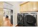 Convenient laundry room with side-by-side washer/dryer and cabinetry, located near the kitchen at 7258 Sashaying Spirit Ct, Las Vegas, NV 89131