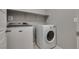 Efficient laundry room with modern washer and dryer, featuring built in shelving and tile flooring at 7559 Chimney Point Ct, Las Vegas, NV 89166