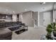 Open-concept living room with dark-gray oversized sofa, modern decor, and access to the kitchen and entryway at 7559 Chimney Point Ct, Las Vegas, NV 89166