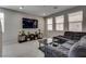 A modern living room with a dark-gray sofa, entertainment center, and natural light from three windows at 7559 Chimney Point Ct, Las Vegas, NV 89166
