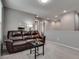Comfortable living room featuring a brown leather sofa and neutral gray walls with bright, recessed lighting at 7559 Chimney Point Ct, Las Vegas, NV 89166