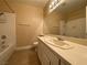 Bathroom with a single sink vanity, large mirror, and a shower and tub at 7604 Cruz Bay Ct, Las Vegas, NV 89128