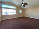 Spacious bedroom featuring large windows, neutral walls, and a stylish ceiling fan at 7604 Cruz Bay Ct, Las Vegas, NV 89128