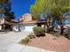 Charming two-story home with a two-car garage and desert landscaping under a clear blue sky at 7604 Cruz Bay Ct, Las Vegas, NV 89128