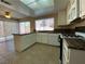 Bright and sunny kitchen with tile flooring, white cabinetry, granite counters, and sliding doors at 7604 Cruz Bay Ct, Las Vegas, NV 89128