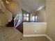 Bright living room with staircase, neutral paint, tiled entry, and large windows for natural light at 7604 Cruz Bay Ct, Las Vegas, NV 89128