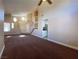 Spacious living room features vaulted ceilings, neutral paint, carpet, and bright views to entryway at 7604 Cruz Bay Ct, Las Vegas, NV 89128