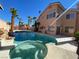 Backyard swimming pool and spa surrounded by lush palm trees at 7604 Cruz Bay Ct, Las Vegas, NV 89128