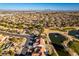 Wide aerial view of a community with a well-manicured golf course, serene lake, and beautiful homes at 8713 Litchfield Ave, Las Vegas, NV 89134