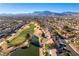 Sweeping aerial view showcasing a lush golf course community with stunning mountain views in the distance at 8713 Litchfield Ave, Las Vegas, NV 89134