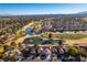 Stunning aerial view of homes bordering a golf course with water features and desert landscaping under a clear sky at 8713 Litchfield Ave, Las Vegas, NV 89134