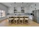 Modern kitchen featuring white cabinets, marble countertops, stainless steel appliances, and a stylish island with seating at 8713 Litchfield Ave, Las Vegas, NV 89134