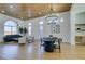 Spacious, open living area featuring modern lighting, wood ceiling, contemporary furniture, and a dining space at 8713 Litchfield Ave, Las Vegas, NV 89134