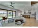 Open concept living area featuring a modern kitchen, fireplace, large windows, and stylish contemporary furniture at 8713 Litchfield Ave, Las Vegas, NV 89134