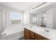 Bright bathroom featuring a soaking tub and a spacious dual sink vanity, perfect for relaxation at 9146 Grand Sunburst Ct, Las Vegas, NV 89149