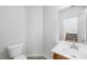 Bathroom with a wood vanity, sink, toilet, and a mirror; next to stairs at 9146 Grand Sunburst Ct, Las Vegas, NV 89149