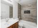 Bathroom featuring a single sink vanity, tiled walls, and a bathtub at 9146 Grand Sunburst Ct, Las Vegas, NV 89149