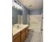 Bathroom with a single vanity, tub and shower combo, light fixtures, and blue paint at 9165 Beauchamp Ave, Las Vegas, NV 89148